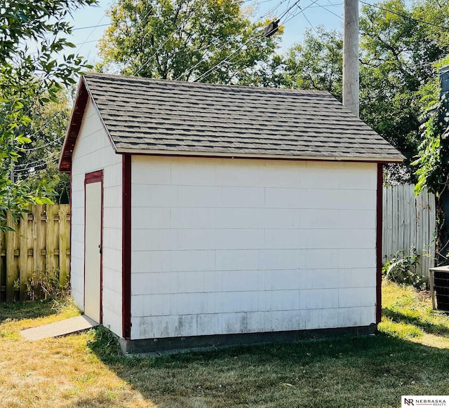 garage featuring a storage unit and fence