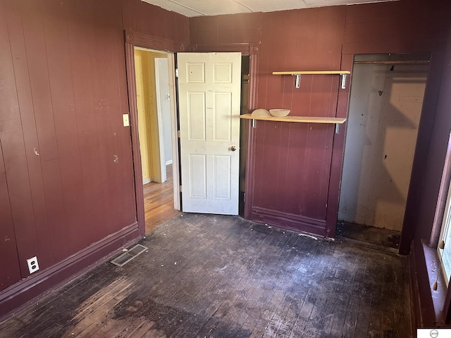 interior space featuring baseboards, visible vents, and dark wood-style flooring