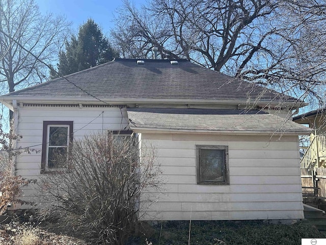 view of side of property featuring a shingled roof