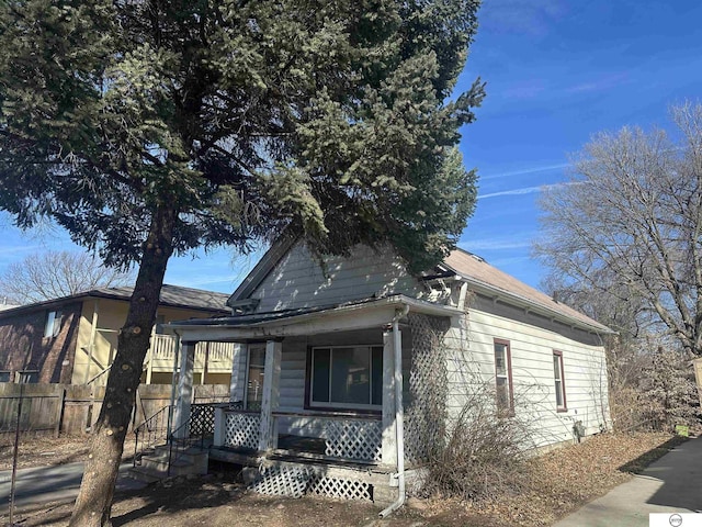 view of front of home with a porch and fence