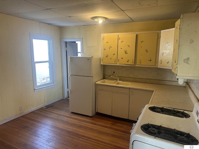 kitchen featuring light countertops, white appliances, dark wood-style flooring, and a sink