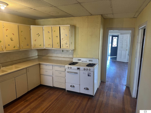 kitchen with dark wood-style flooring, a paneled ceiling, light countertops, a sink, and white gas range oven