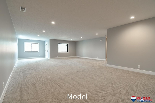 spare room with baseboards, recessed lighting, visible vents, and light colored carpet