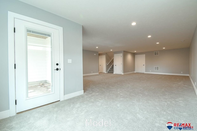 spare room with stairway, visible vents, light colored carpet, and recessed lighting