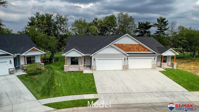 view of front facade featuring a garage, concrete driveway, stone siding, covered porch, and a front yard