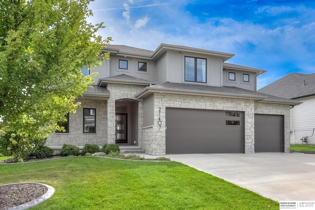 prairie-style house featuring stucco siding, a shingled roof, an attached garage, driveway, and a front lawn