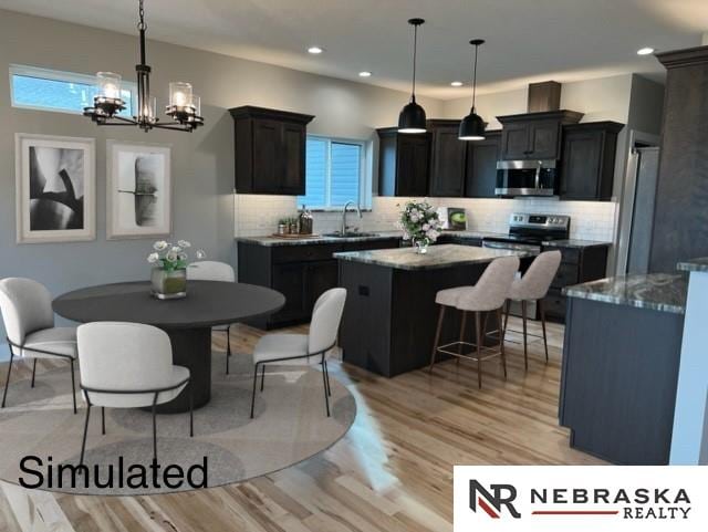 kitchen featuring appliances with stainless steel finishes, a center island, light wood-type flooring, and a sink