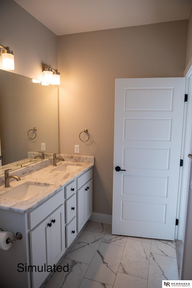 full bathroom featuring double vanity, marble finish floor, baseboards, and a sink