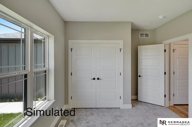 unfurnished bedroom featuring carpet floors, baseboards, visible vents, and a closet