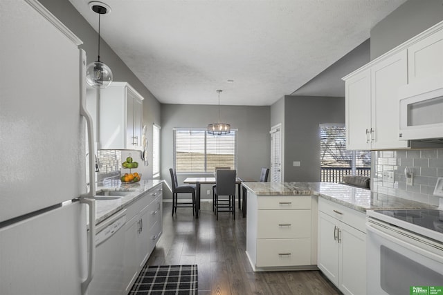 kitchen with tasteful backsplash, white appliances, white cabinetry, and a peninsula