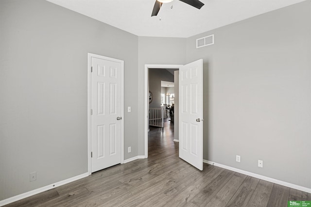 unfurnished bedroom with baseboards, visible vents, ceiling fan, and wood finished floors