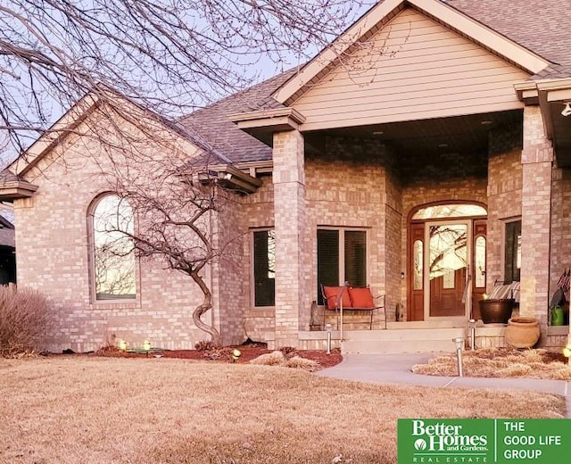 rear view of property with brick siding and roof with shingles