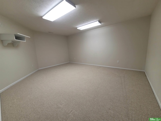 carpeted empty room with baseboards and a textured ceiling