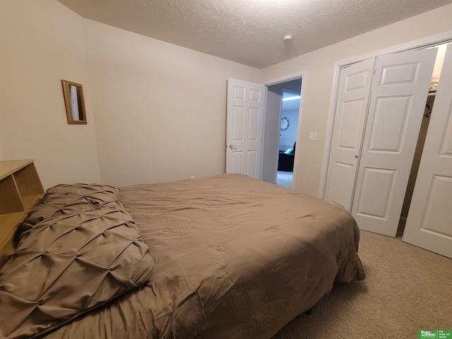 bedroom featuring light carpet, a textured ceiling, and a closet