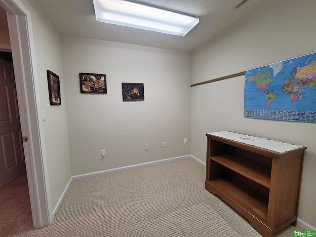 interior space featuring light colored carpet, visible vents, and baseboards