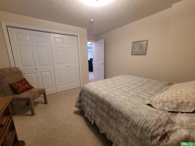 bedroom featuring a textured ceiling, a closet, and light colored carpet