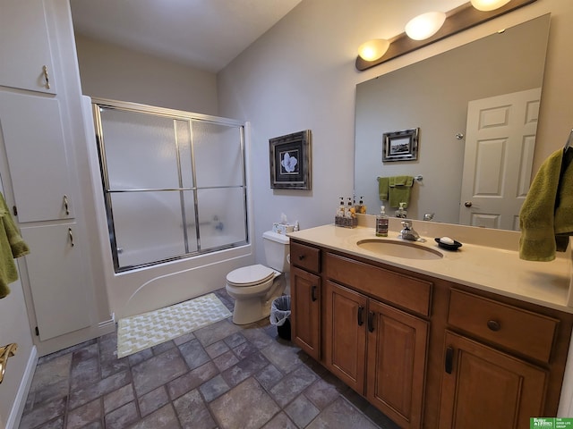 full bathroom with enclosed tub / shower combo, toilet, vanity, and stone tile floors