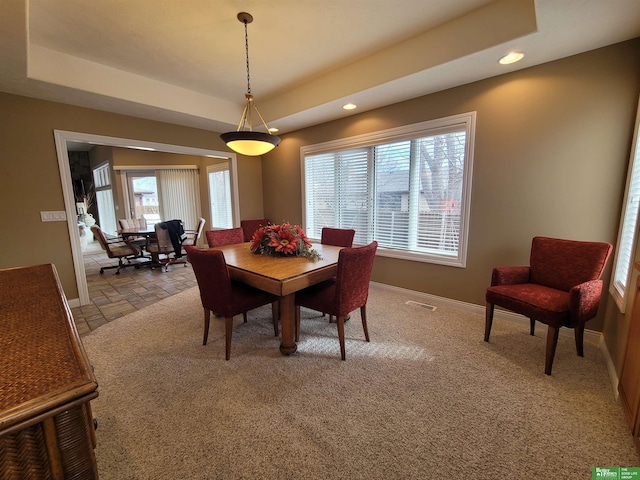 dining room featuring baseboards, a raised ceiling, and recessed lighting