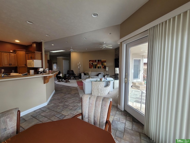 dining area with ceiling fan, recessed lighting, baseboards, and stone tile floors