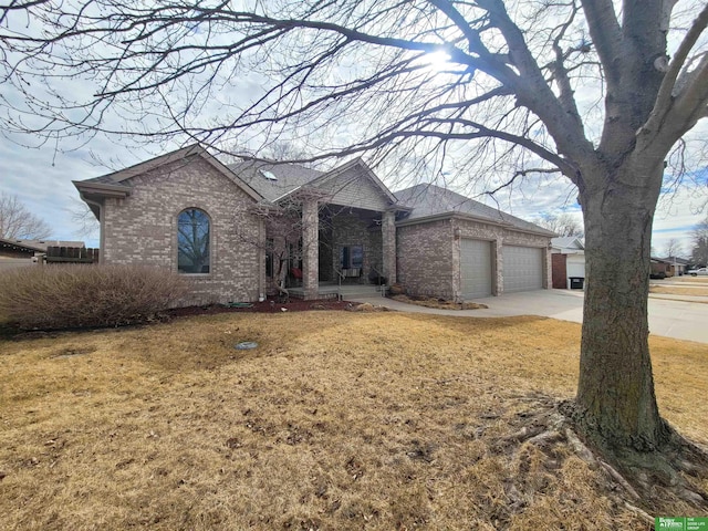 ranch-style home with a garage, driveway, brick siding, and a front lawn