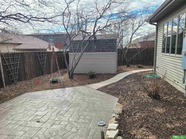 exterior space with an outbuilding, a patio, a shed, and a fenced backyard