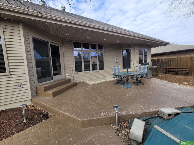 view of patio with entry steps, fence, and grilling area