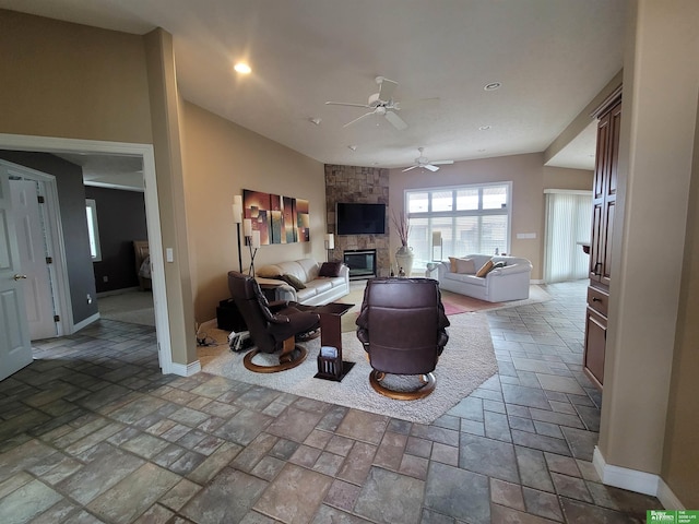 living area with a stone fireplace, stone tile floors, recessed lighting, and baseboards