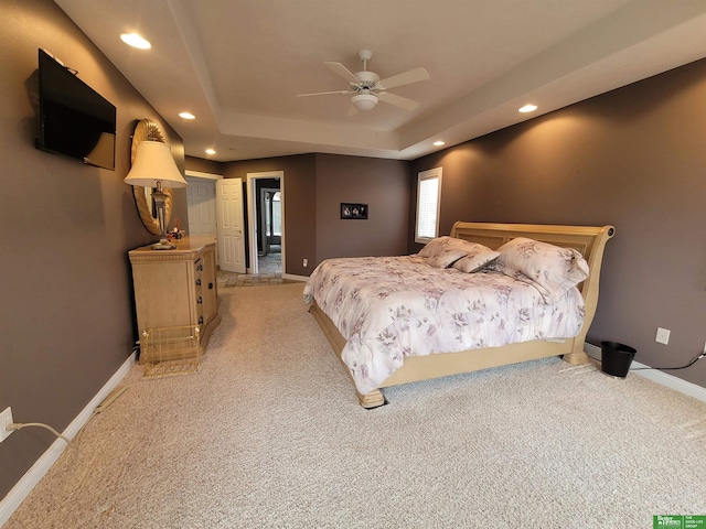 bedroom with recessed lighting, baseboards, a raised ceiling, and light colored carpet