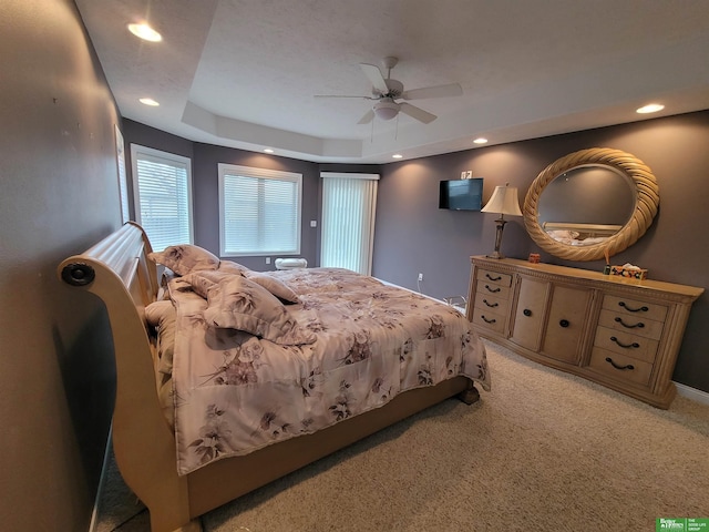 bedroom with a ceiling fan, recessed lighting, a raised ceiling, and light colored carpet