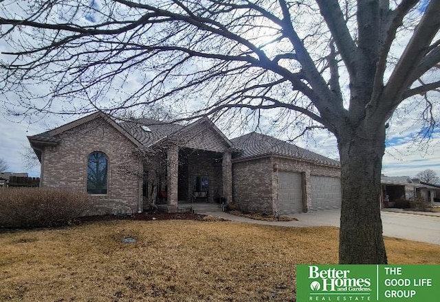 view of front of home with an attached garage, concrete driveway, and brick siding