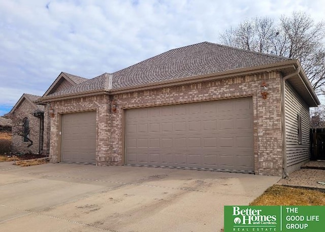 view of front of house featuring an attached garage, concrete driveway, and brick siding