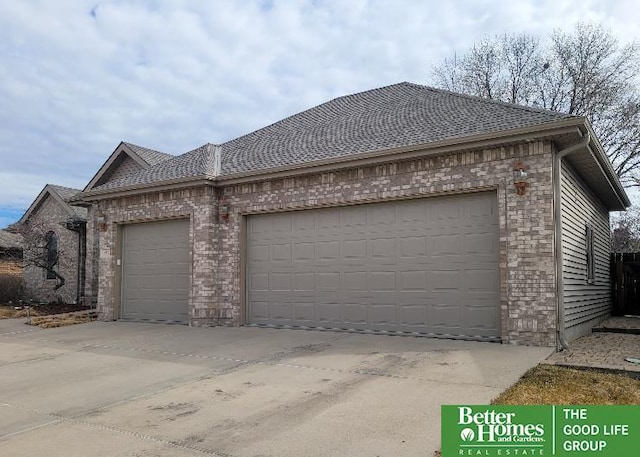 view of front of house with an attached garage, driveway, and brick siding