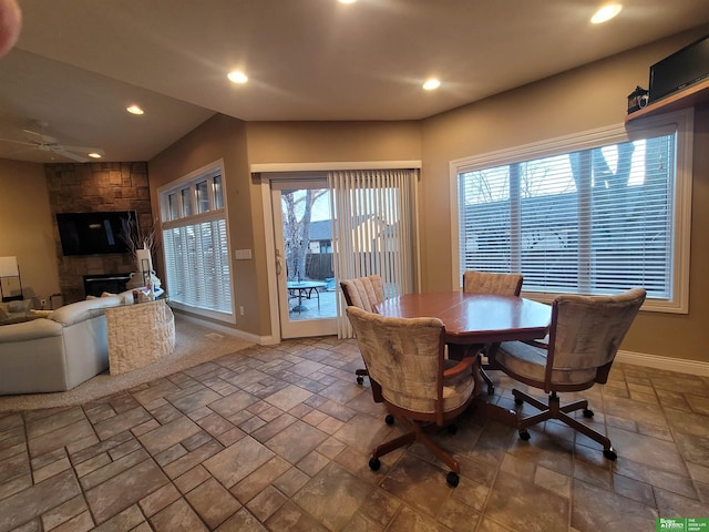 dining room with recessed lighting, stone tile floors, baseboards, and a stone fireplace