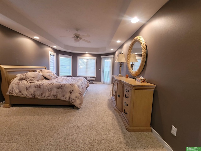 bedroom featuring light carpet, baseboards, a raised ceiling, ceiling fan, and recessed lighting