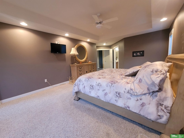 carpeted bedroom with a ceiling fan, recessed lighting, a raised ceiling, and baseboards