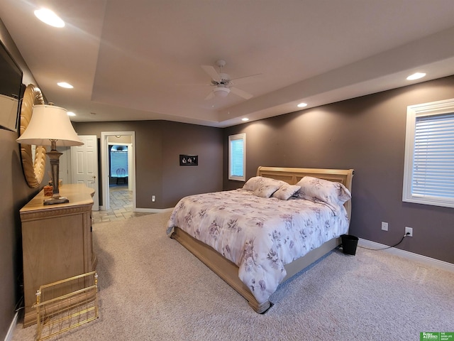 bedroom with light carpet, baseboards, a raised ceiling, a ceiling fan, and recessed lighting