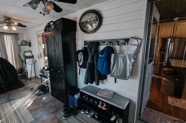 mudroom featuring stone finish flooring, a drop ceiling, and ceiling fan