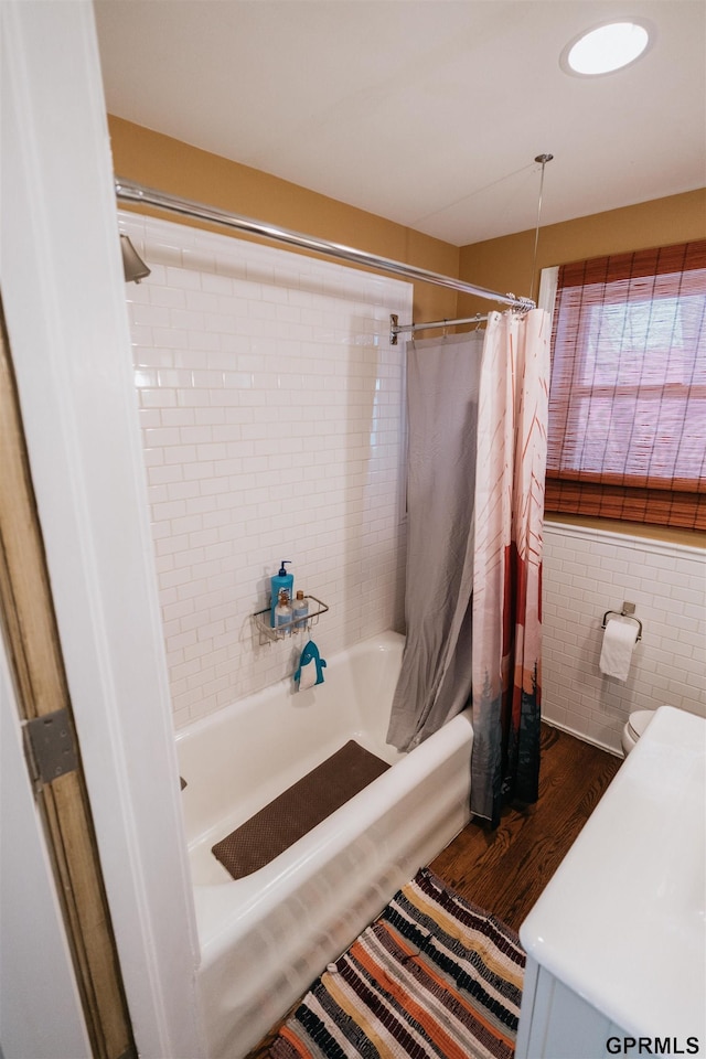 bathroom featuring wood finished floors and shower / bath combo with shower curtain