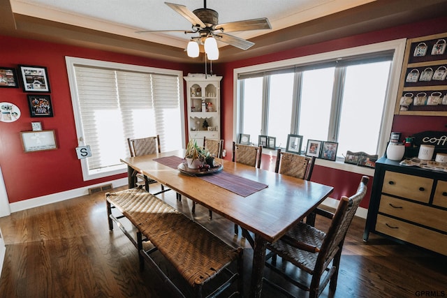 dining space featuring a ceiling fan, visible vents, dark wood finished floors, and baseboards