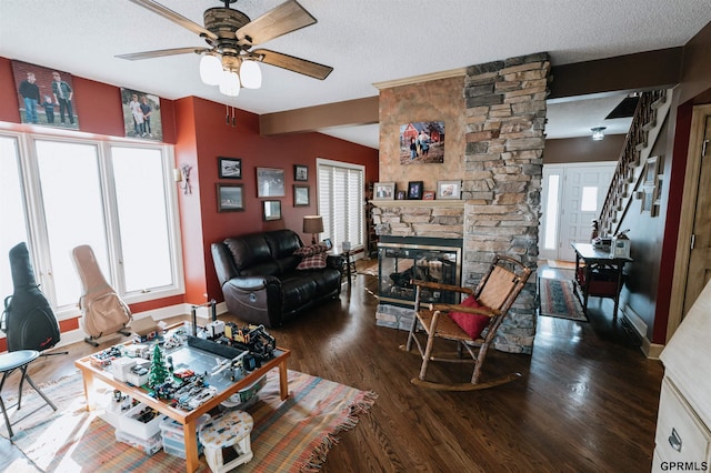 living room featuring a textured ceiling, wood finished floors, and a healthy amount of sunlight