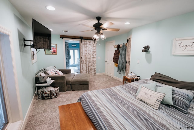 bedroom with ceiling fan, a barn door, recessed lighting, baseboards, and carpet