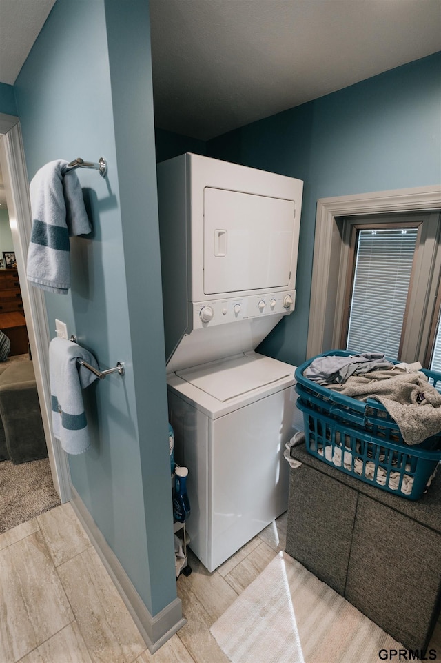 laundry room featuring laundry area and stacked washer / dryer