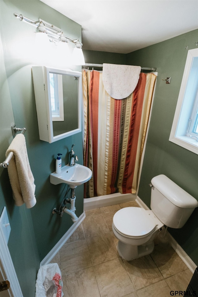 full bath with toilet, tile patterned floors, baseboards, and a shower with shower curtain