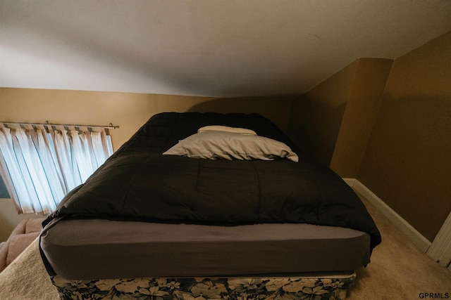 bedroom with vaulted ceiling, carpet floors, and baseboards