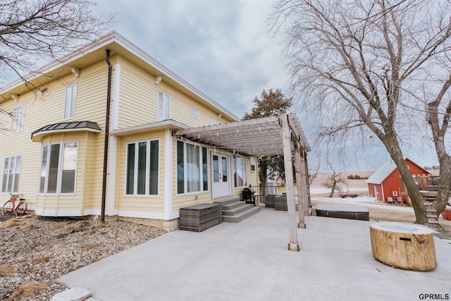 back of house featuring entry steps, a pergola, and a patio