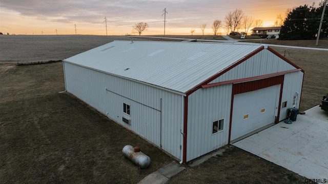 outdoor structure at dusk featuring a yard and an outdoor structure