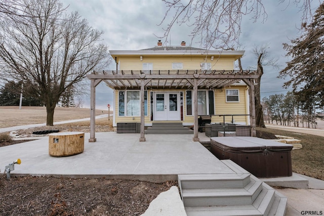 rear view of house featuring french doors, a patio, a hot tub, entry steps, and a pergola