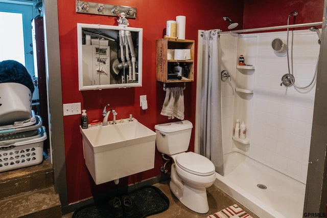 full bath featuring baseboards, a sink, a shower stall, and toilet