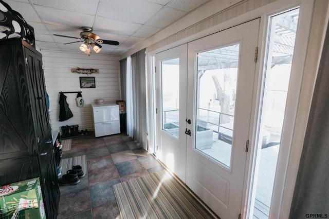 entryway with a paneled ceiling, ceiling fan, stone finish floor, and french doors