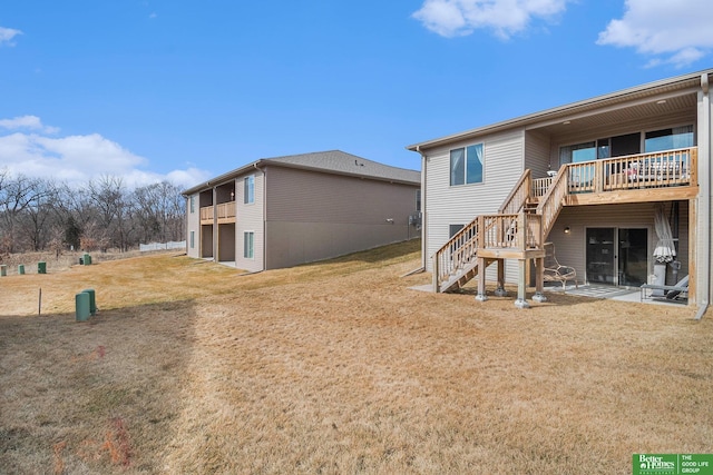 rear view of house featuring stairs and a yard